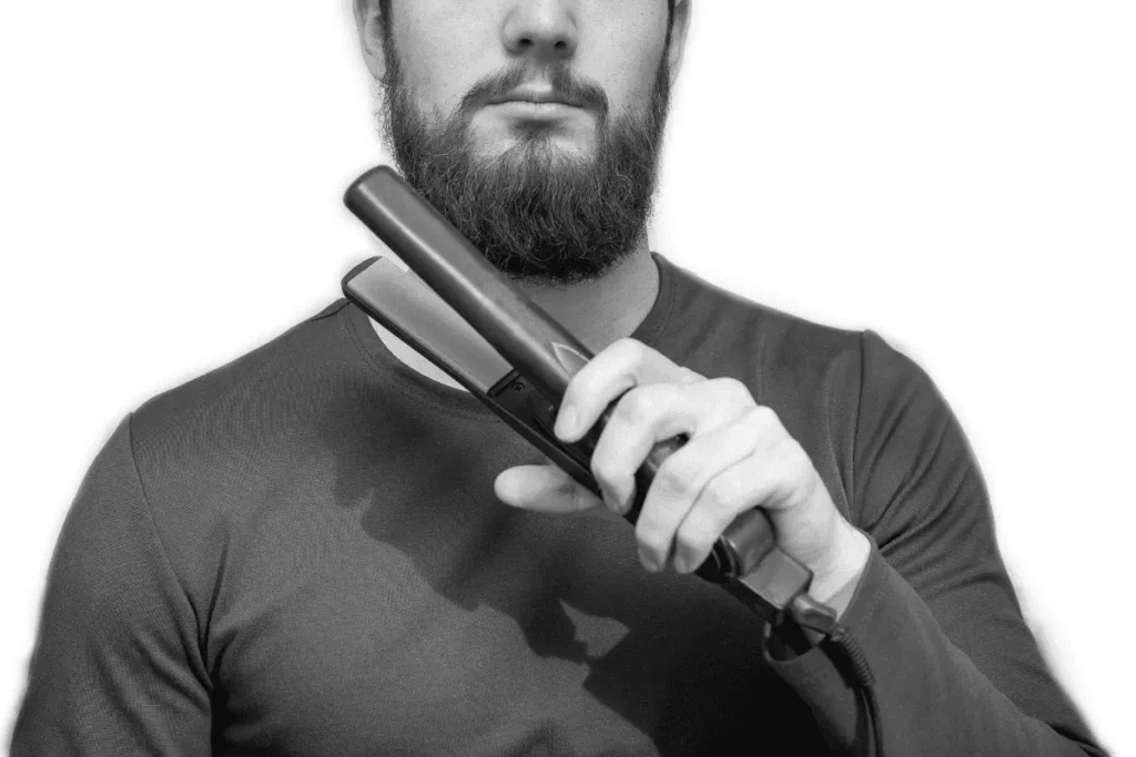 Man using a flat iron on a short beard, illustrating the risk of using the wrong straightening tool.