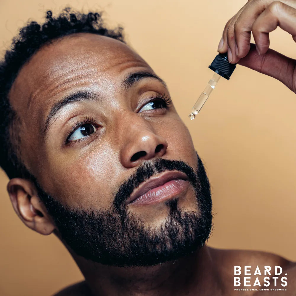 Man applying beard oil with dropper — how to choose and apply beard oil