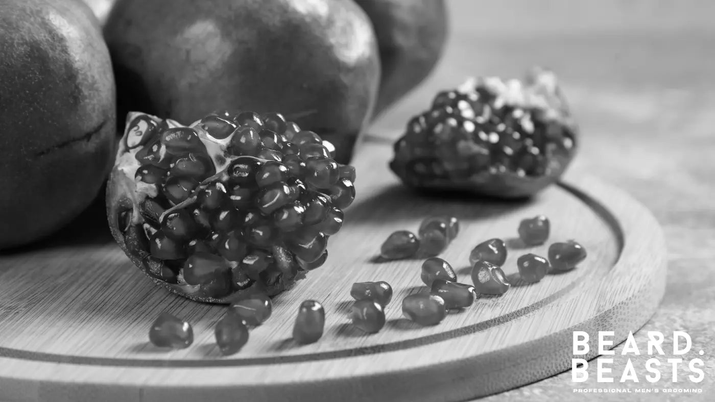 Fresh sliced pomegranate on a wooden board, rich in antioxidants that improve blood circulation and support thicker, healthier beard growth.