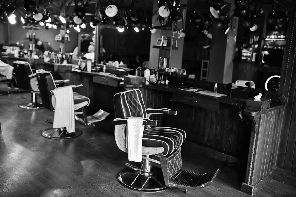 Black-and-white photo of a traditional barbershop interior with empty chairs, capturing the relaxed atmosphere created by barbershop music.