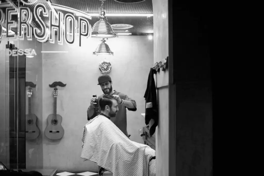 A vintage vinyl record player sitting on a barber station next to grooming tools, illustrating how music equipment contributes to a barbershop's unique personality and decor.