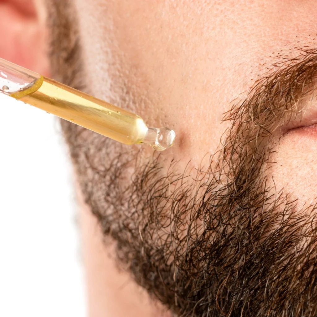 Beard oil being applied to the skin underneath a beard.