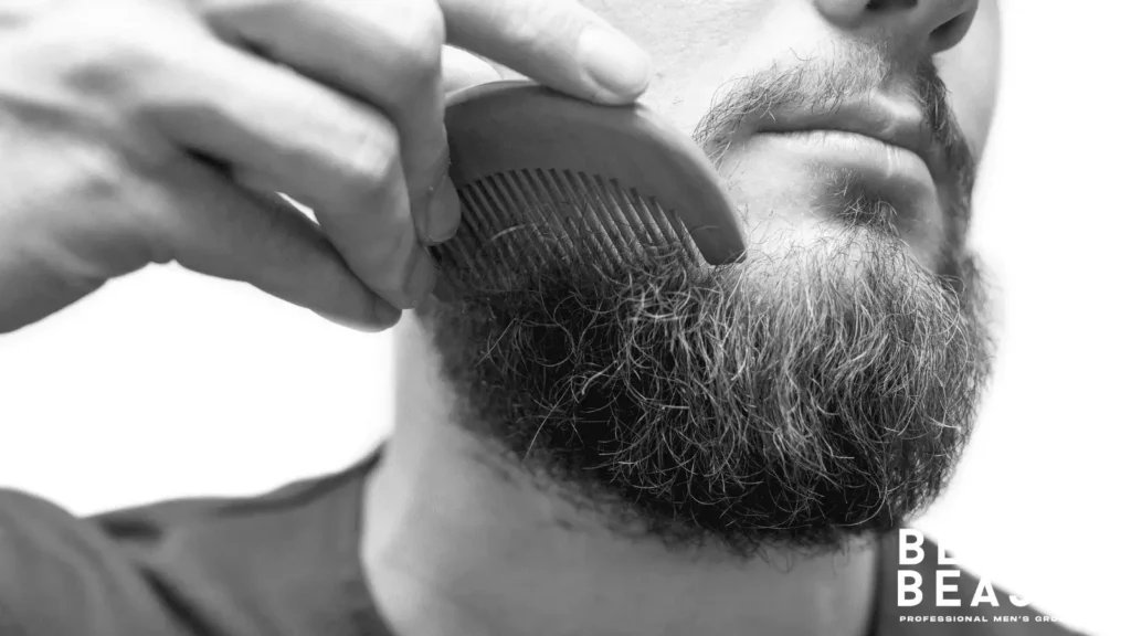 Man brushing beard with wooden comb to remove dry skin flakes without itch