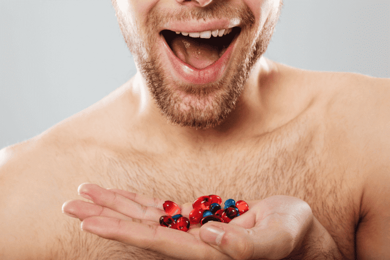 Man holding multiple supplement capsules while questioning whether beard growth vitamins actually work