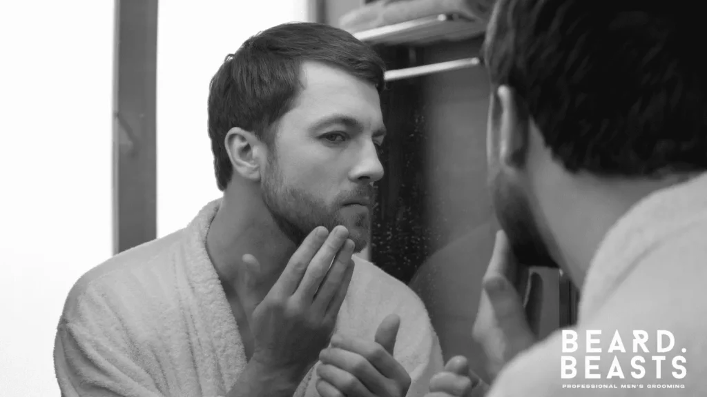 Man checking his beard in the mirror for beard flakes