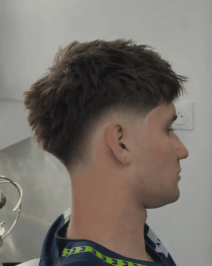 Side profile of a men’s drop fade haircut showing the fade dropping behind the ear and following the natural curve of the head