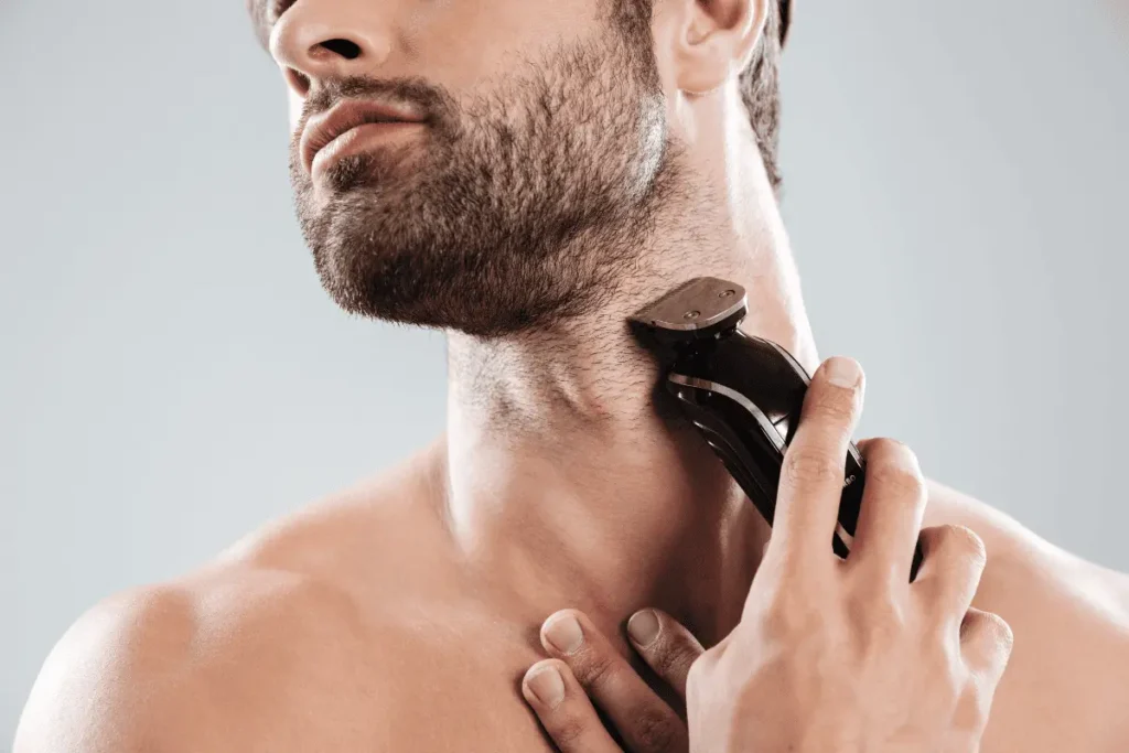 Man trimming short beard neckline with electric trimmer