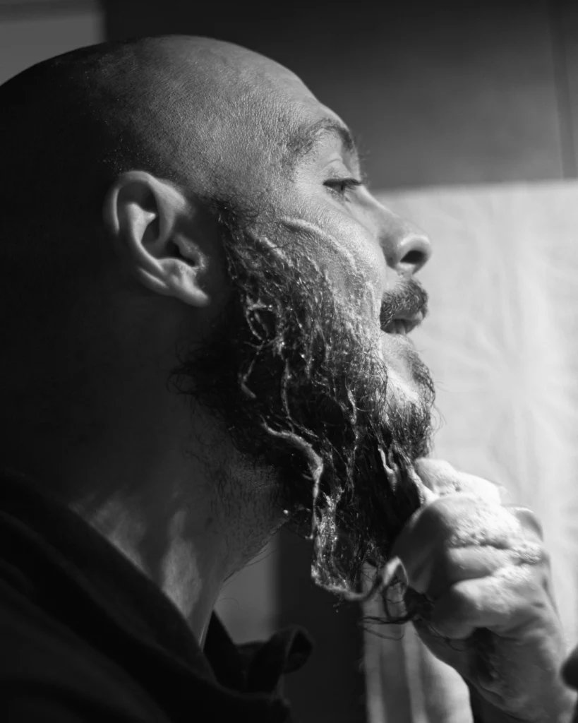 Man washing his beard with a foaming beard wash, showing how the best beard washes for men should clean the beard without leaving it rough or dry.