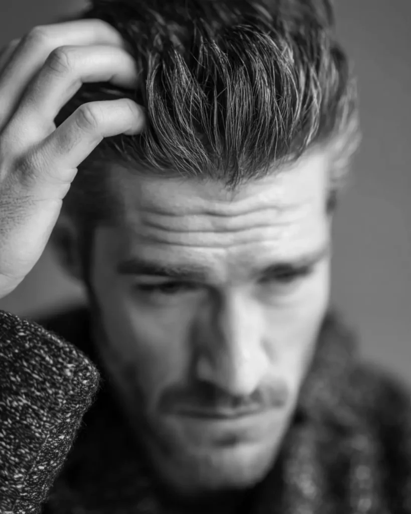 Man running his fingers through thick wavy hair before straightening